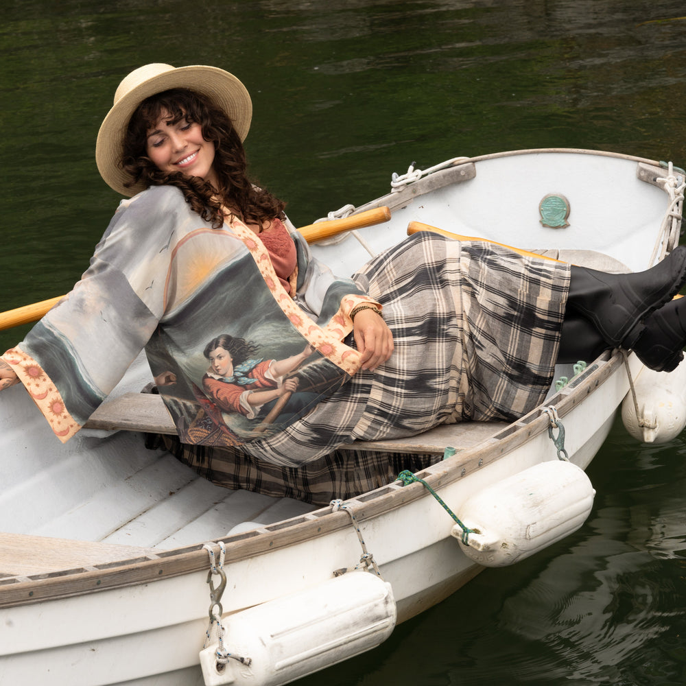 
                  
                    Model wearing the Hold Fast Pixie Duster featuring a Victorian woman rowing through a storm, seagulls, and rainbow horizon – Market of Stars.
                  
                