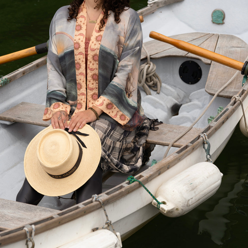 
                  
                    Model wearing the Hold Fast Pixie Duster featuring a Victorian woman rowing through a storm, seagulls, and rainbow horizon – Market of Stars.
                  
                