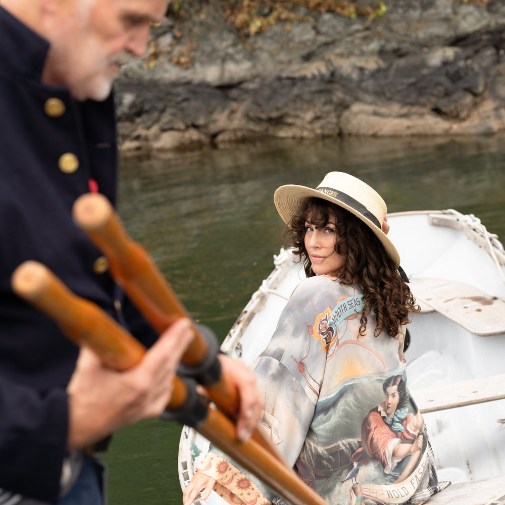 
                  
                    Model wearing the Hold Fast Pixie Duster featuring a Victorian woman rowing through a storm, seagulls, and rainbow horizon – Market of Stars.
                  
                