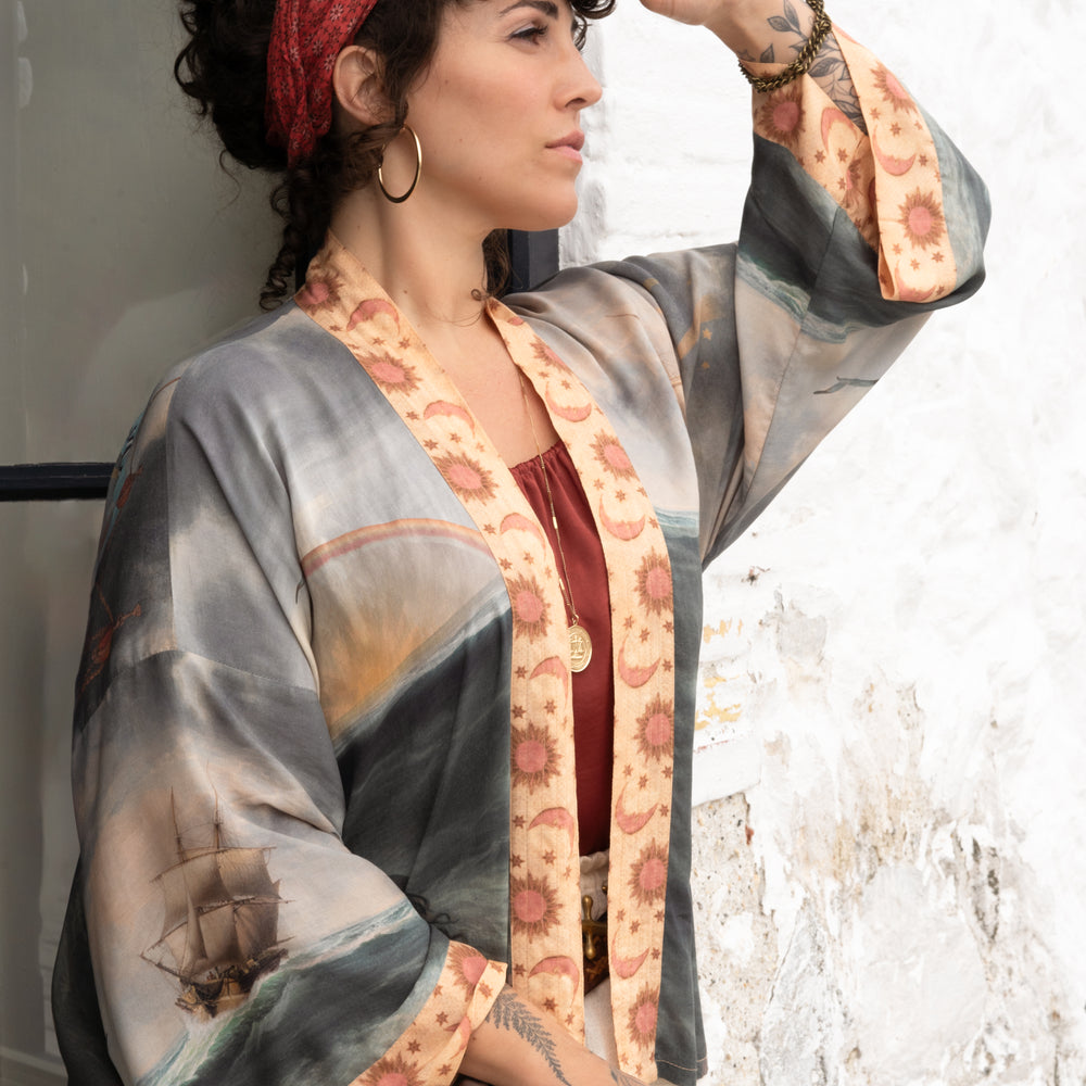 
                  
                    Model wearing the Hold Fast Pixie Duster featuring a Victorian woman rowing through a storm, seagulls, and rainbow horizon – Market of Stars.
                  
                