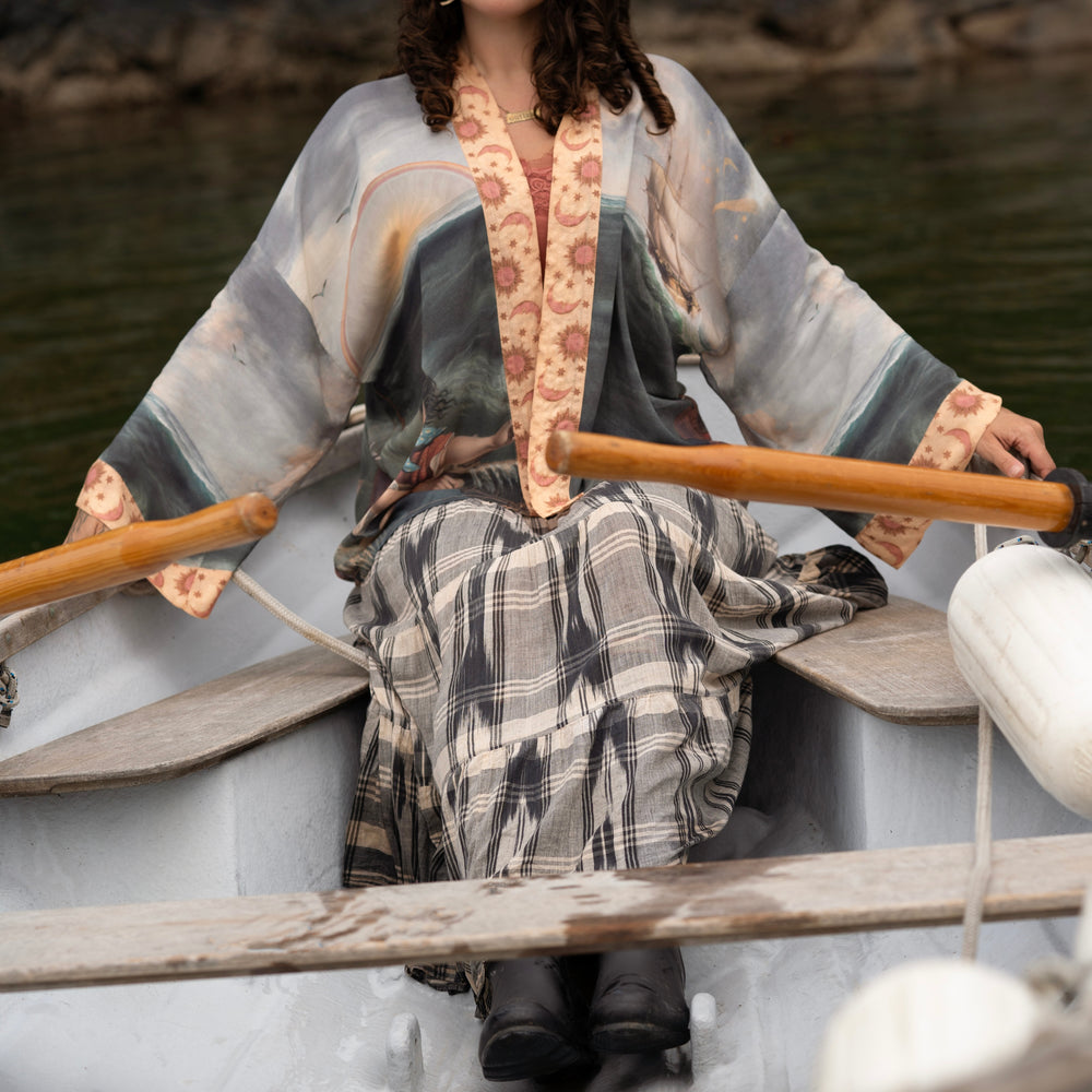 
                  
                    Model wearing the Hold Fast Pixie Duster featuring a Victorian woman rowing through a storm, seagulls, and rainbow horizon – Market of Stars.
                  
                