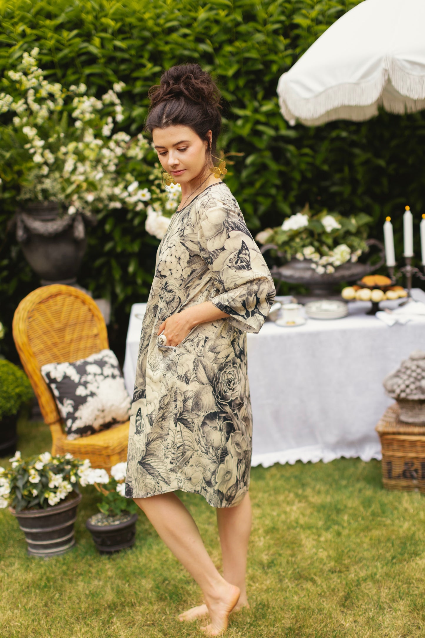 Model wearing a knee-length shift dress featuring black-and-ivory floral lithographs from the 1900's - Market of Stars
