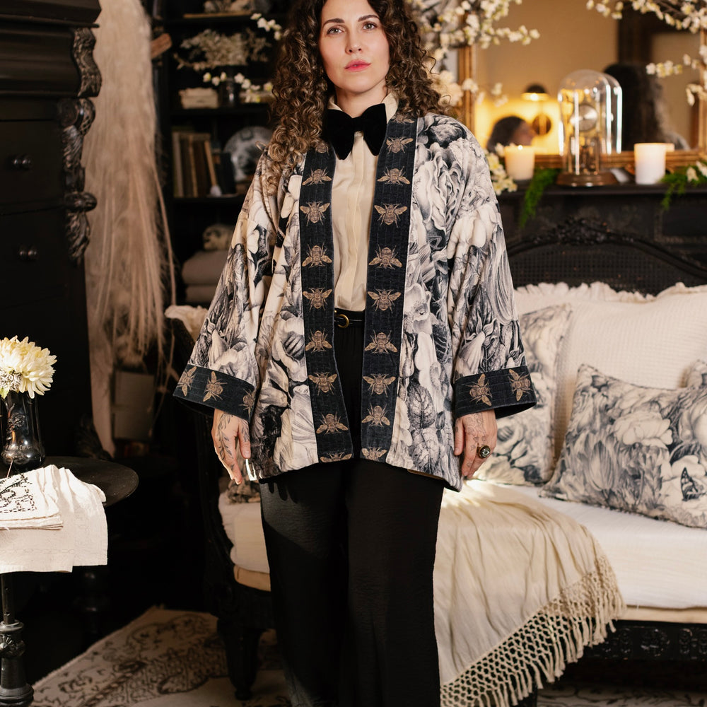 
                  
                    Model wearing a soft cotton velvet duster ft. 1900's floral lithographs. A garden dreamt up in ink - Market of Stars
                  
                