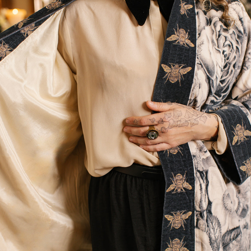
                  
                    Model wearing a soft cotton velvet duster ft. 1900's floral lithographs. A garden dreamt up in ink - Market of Stars
                  
                