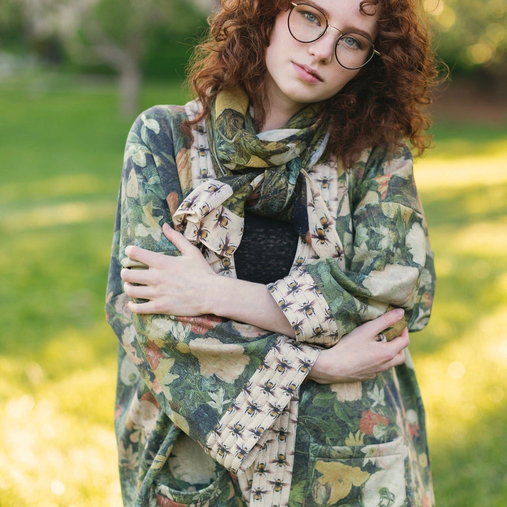 
                  
                    Model wearing the I Dream in Flowers Cottage Cardigan featuring painterly floral artwork and Victorian bumblebee trim, perfect for cozy layering – Market of Stars
                  
                