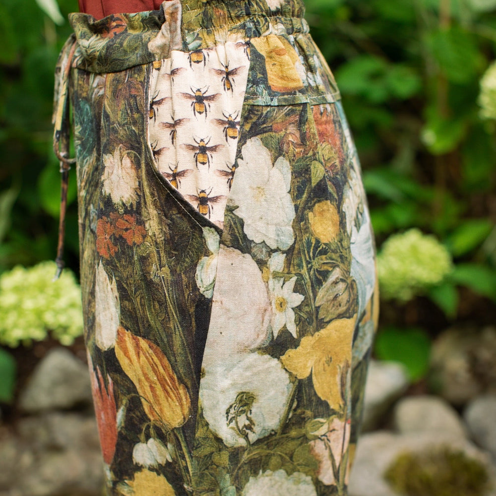 Model wearing the I Dream in Flowers Artist Pants featuring romantic floral artwork by Jan Brueghel and Victorian bumblebee trim, styled for everyday ease – Market of Stars