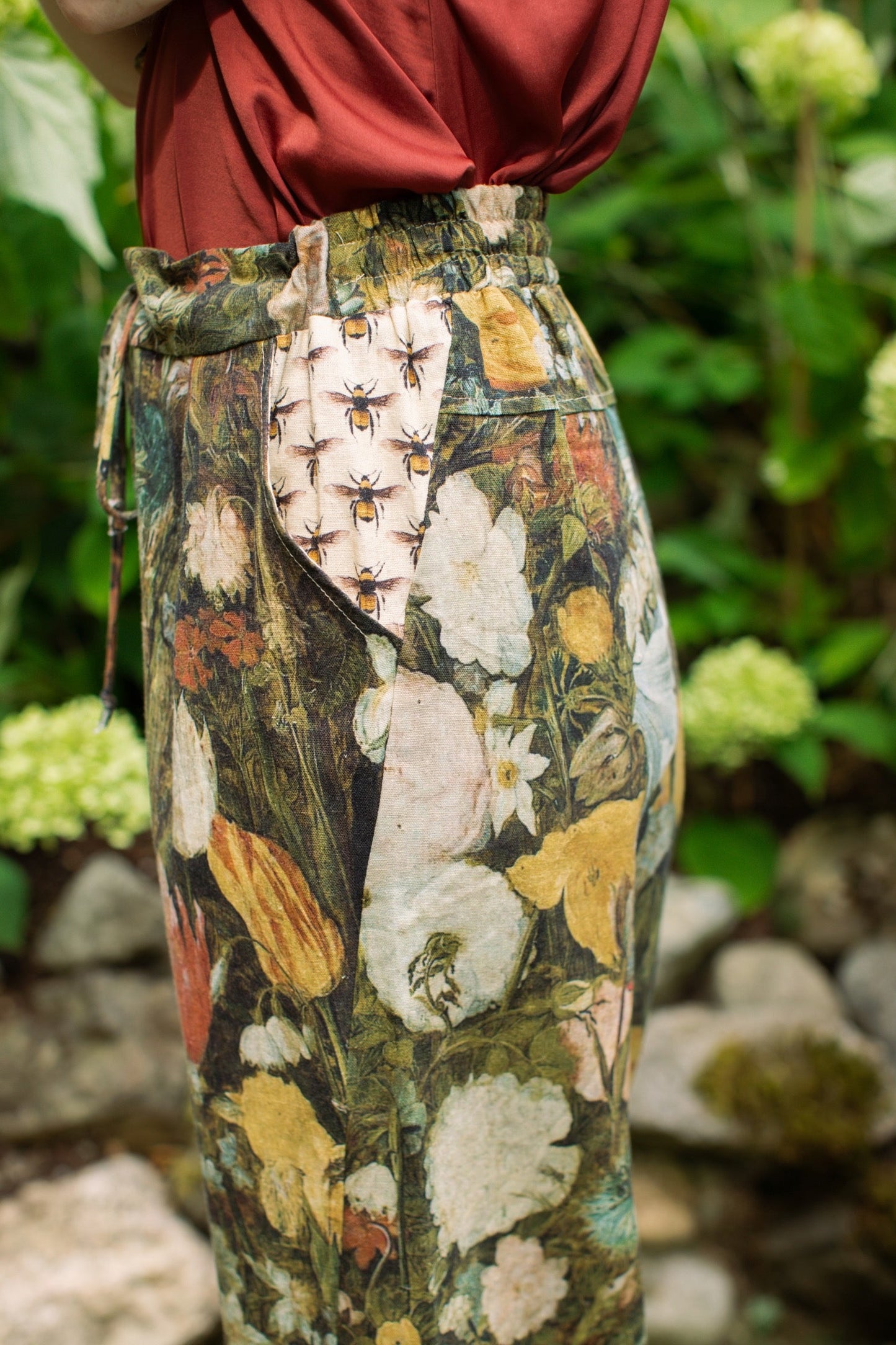 Model wearing the I Dream in Flowers Artist Pants featuring romantic floral artwork by Jan Brueghel and Victorian bumblebee trim, styled for everyday ease – Market of Stars