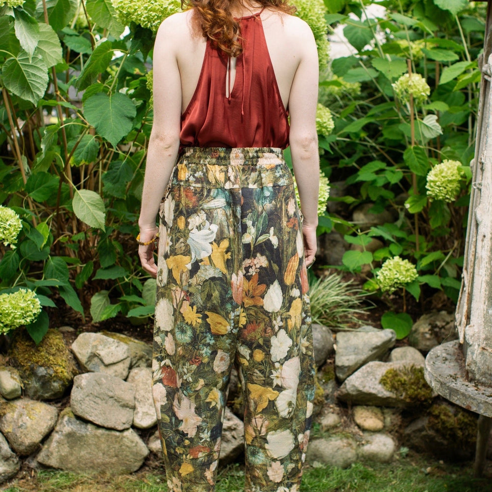 
                  
                    Model wearing the I Dream in Flowers Artist Pants featuring romantic floral artwork by Jan Brueghel and Victorian bumblebee trim, styled for everyday ease – Market of Stars
                  
                