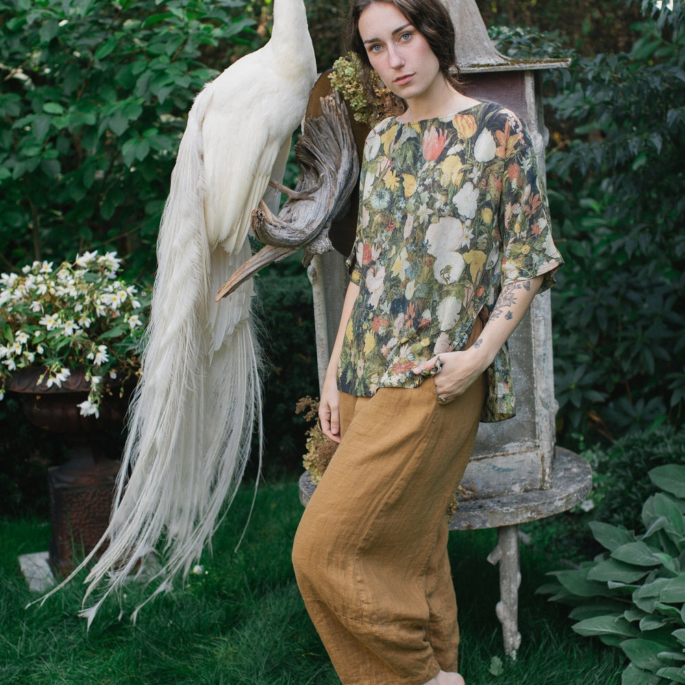 
                  
                    Model wearing the I Dream in Flowers Luxe Tee featuring painterly florals by Jan Brueghel and hidden bumblebee trim – Market of Stars.
                  
                