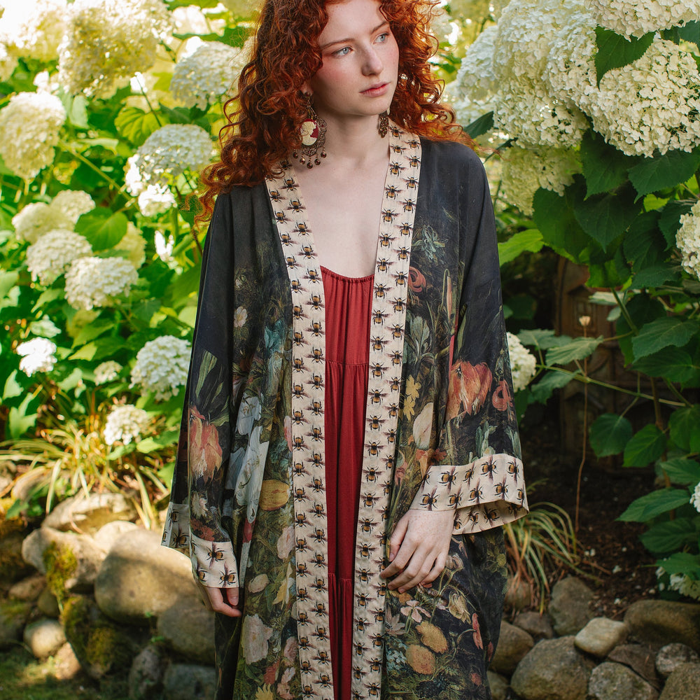 Model wearing the I Dream in Flowers Opera Duster featuring floral oil painting by Jan Brueghel and Victorian bumblebee trim – Market of Stars.