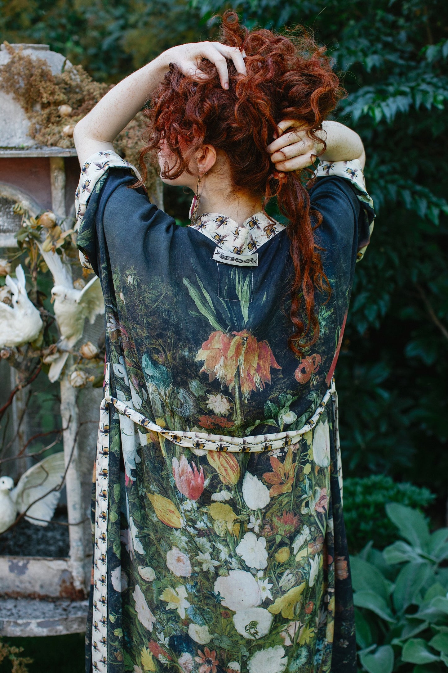 Model wearing the I Dream in Flowers Opera Duster featuring floral oil painting by Jan Brueghel and Victorian bumblebee trim – Market of Stars.