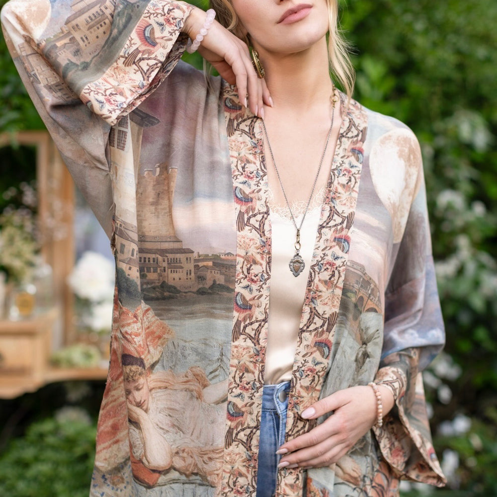 
                  
                    Model wearing the Imaginarium matinee duster featuring a dreamy collage of historic art, candle chandelier, and sleeping muse inspired by Victorian paintings – Market of Stars
                  
                