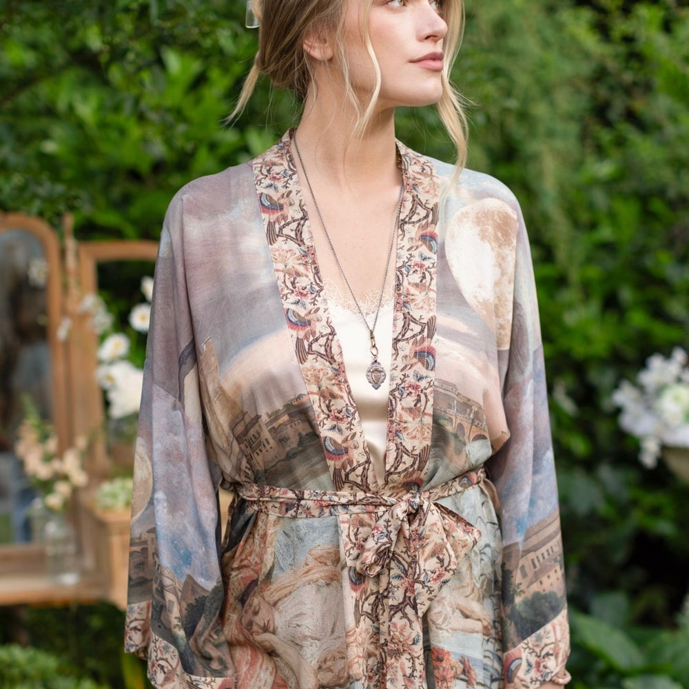 
                  
                    Model wearing the Imaginarium matinee duster featuring a dreamy collage of historic art, candle chandelier, and sleeping muse inspired by Victorian paintings – Market of Stars
                  
                