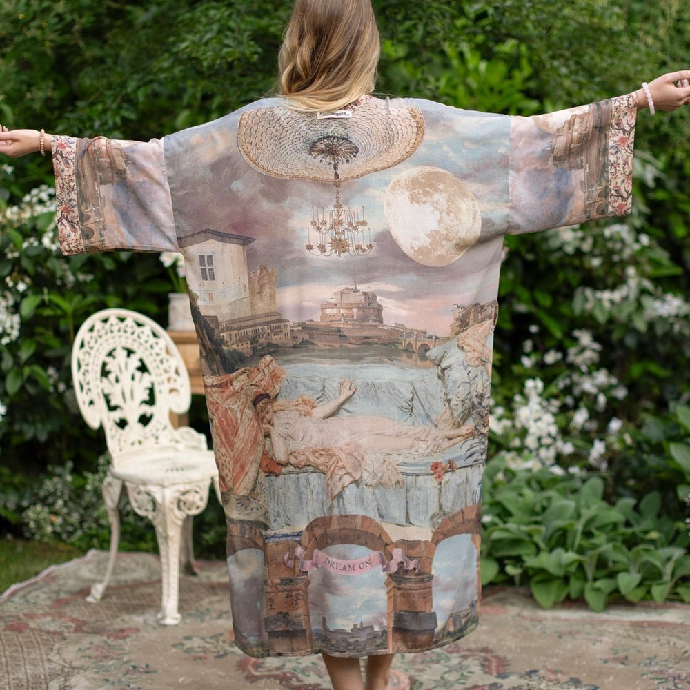Model standing in airy Imaginarium opera duster featuring layered dreamscape art, candlelit chandelier, and sleeping muse inspired by Victorian paintings – Market of Stars