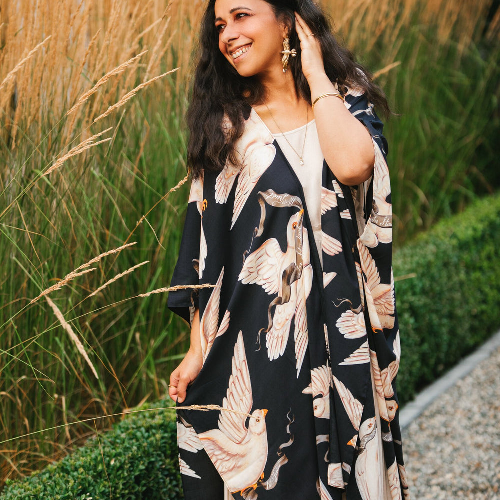 
                  
                    Model wearing the original Market of Stars kimono featuring Victorian-inspired doves and the words “In Stardust We Trust” — a tribute to dreams and possibility – Market of Stars.
                  
                