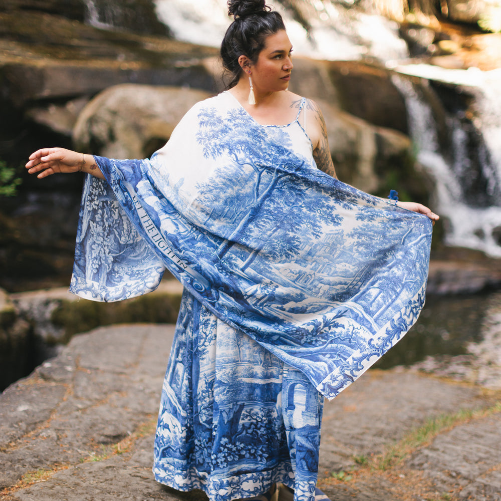 
                  
                    Let the Light In airy bamboo viscose scarf featuring print of Delft blue and white pottery, and positive message of light and hope - Market of Stars
                  
                