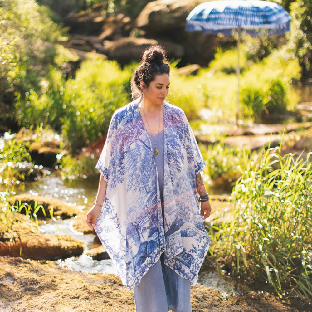
                  
                    Model wearing Let the Light In Goddess kimono duster featuring print of Delft blue and white landscape pottery, and positive message of light and hope - Market of Stars
                  
                