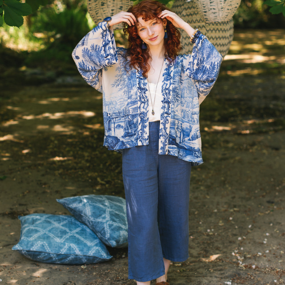 
                  
                    Model wearing Let the Light In cropped Pixie duster featuring print of Delft blue and white landscape pottery, and positive message of light and hope - Market of Stars
                  
                