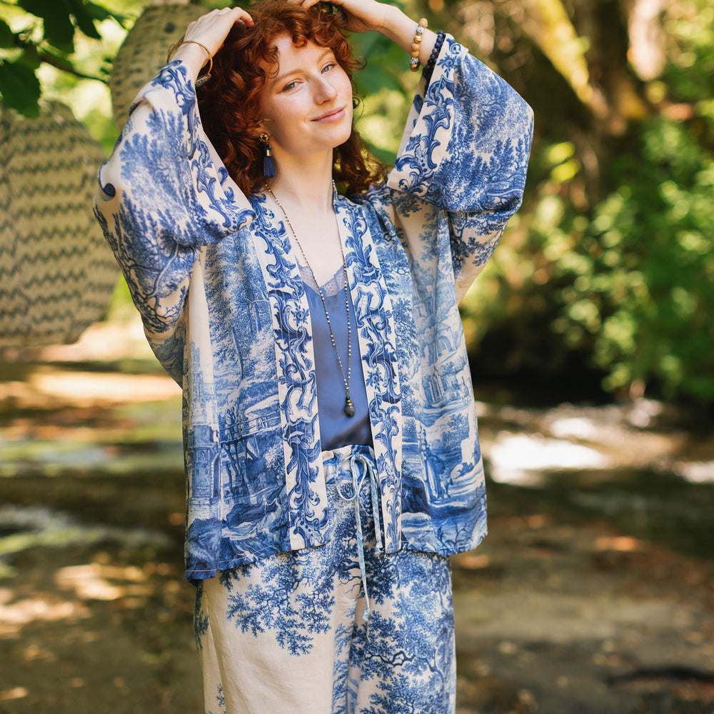 
                  
                    Model wearing Let the Light In cropped Pixie duster featuring print of Delft blue and white landscape pottery, and positive message of light and hope - Market of Stars
                  
                