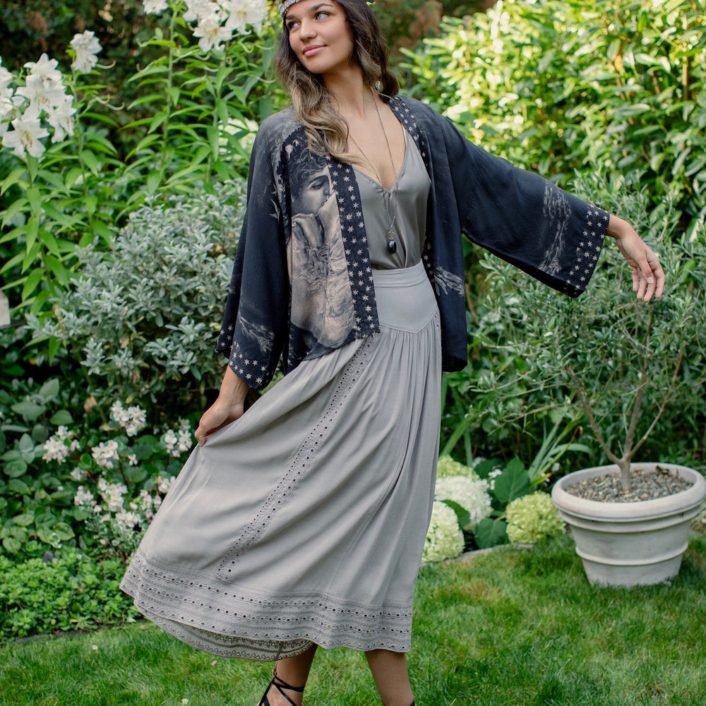 
                  
                    Model wearing Love Conquers All Kimono featuring an 1800s heart-shaped embrace, doves, crescent moon, and the words Amor Vincit Omnia – Market of Stars.
                  
                