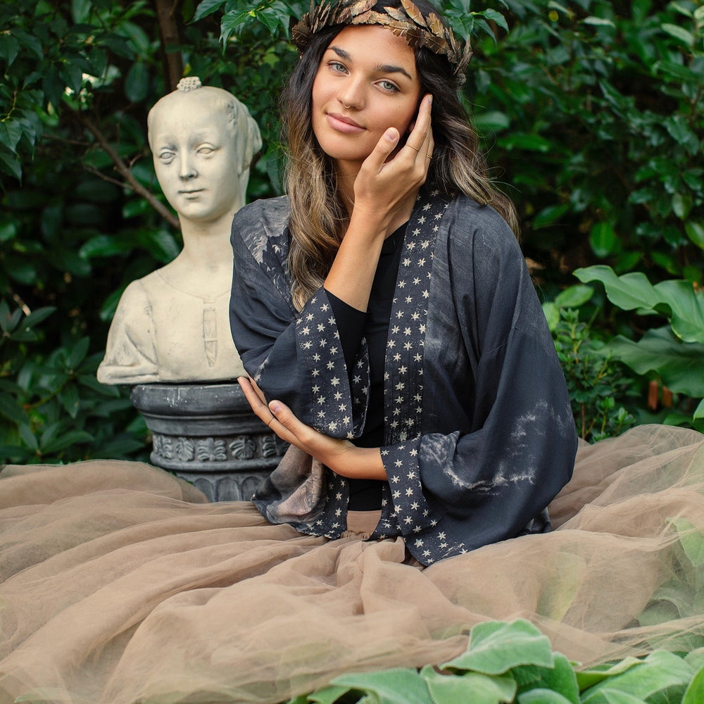 
                  
                    Model wearing Love Conquers All Kimono featuring an 1800s heart-shaped embrace, doves, crescent moon, and the words Amor Vincit Omnia – Market of Stars.
                  
                