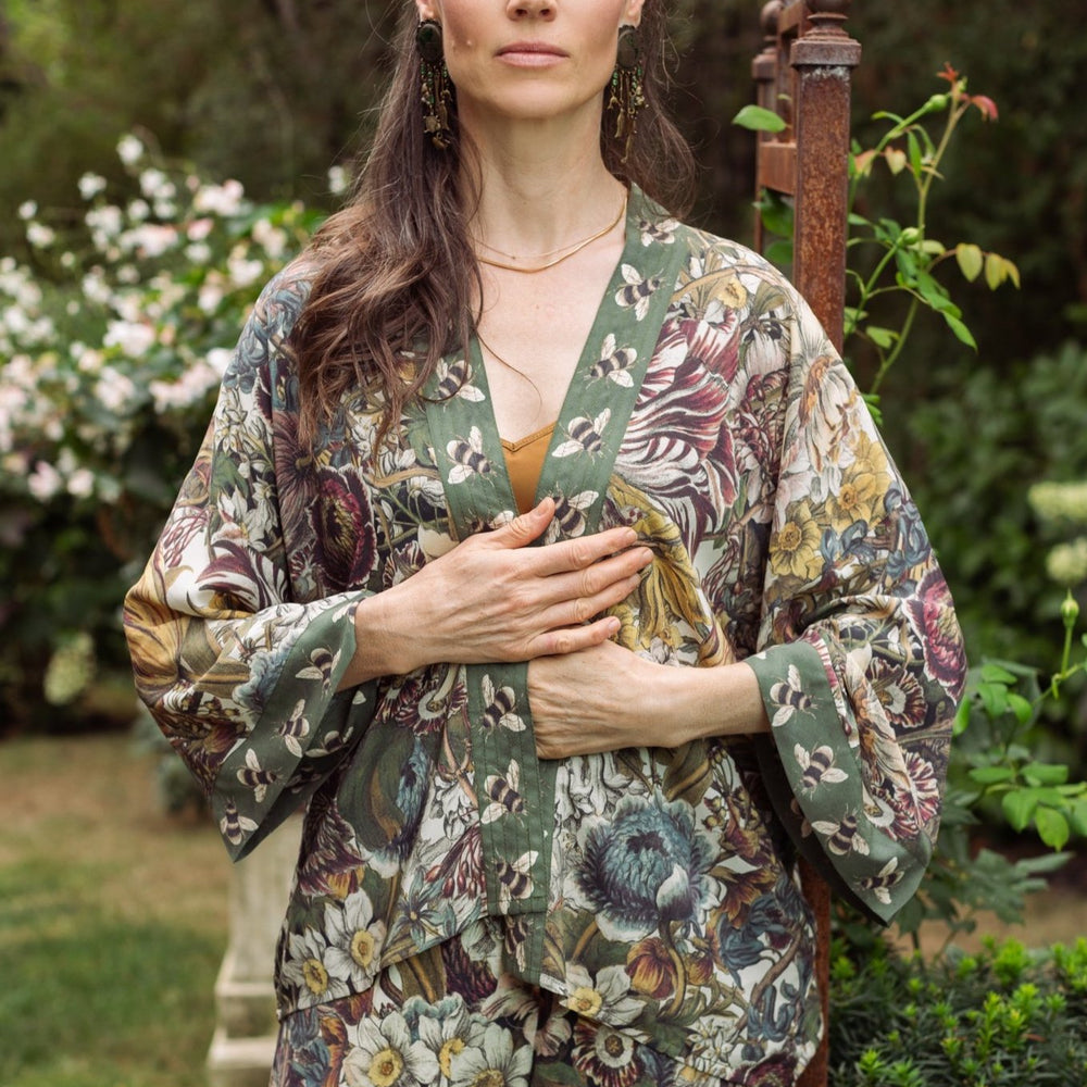 
                  
                    Model wearing Love Grows Wild Pixie Duster featuring hand-coloured 1700s floral etchings and charming bumblebee trim, celebrating the joy of abundance – Market of Stars.
                  
                