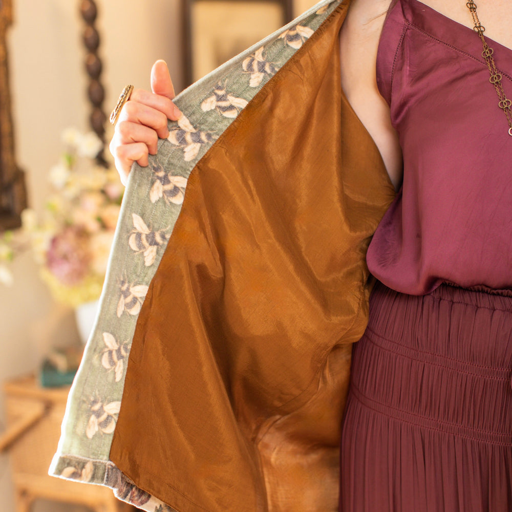 
                  
                    Model wearing a soft cotton velvet duster featuring lush 1700s botanical blooms and bumblebee trim - Market of Stars
                  
                