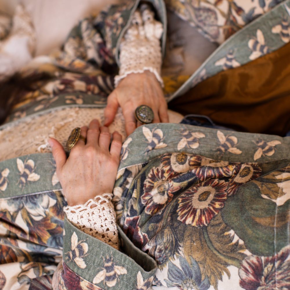 
                  
                    Model wearing a soft cotton velvet duster featuring lush 1700s botanical blooms and bumblebee trim - Market of Stars
                  
                