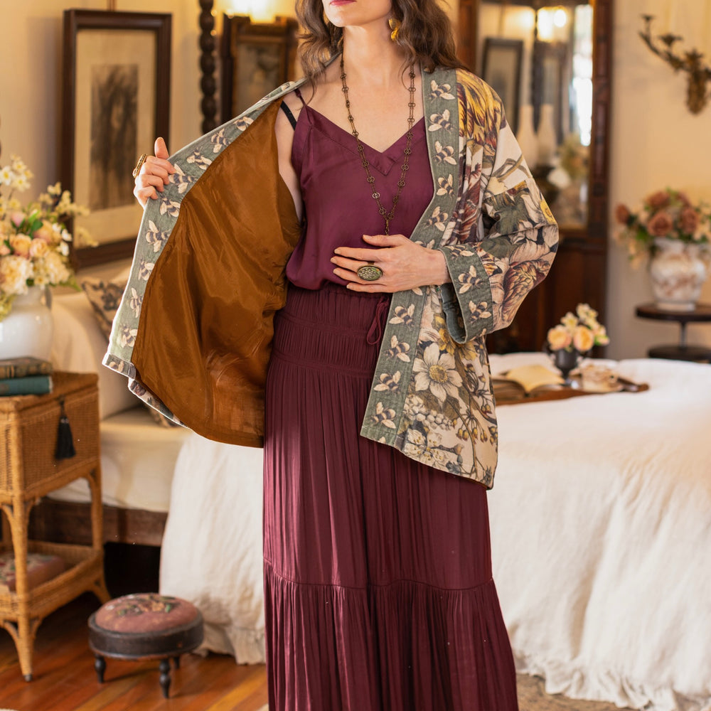 
                  
                    Model wearing a soft cotton velvet duster featuring lush 1700s botanical blooms and bumblebee trim - Market of Stars
                  
                
