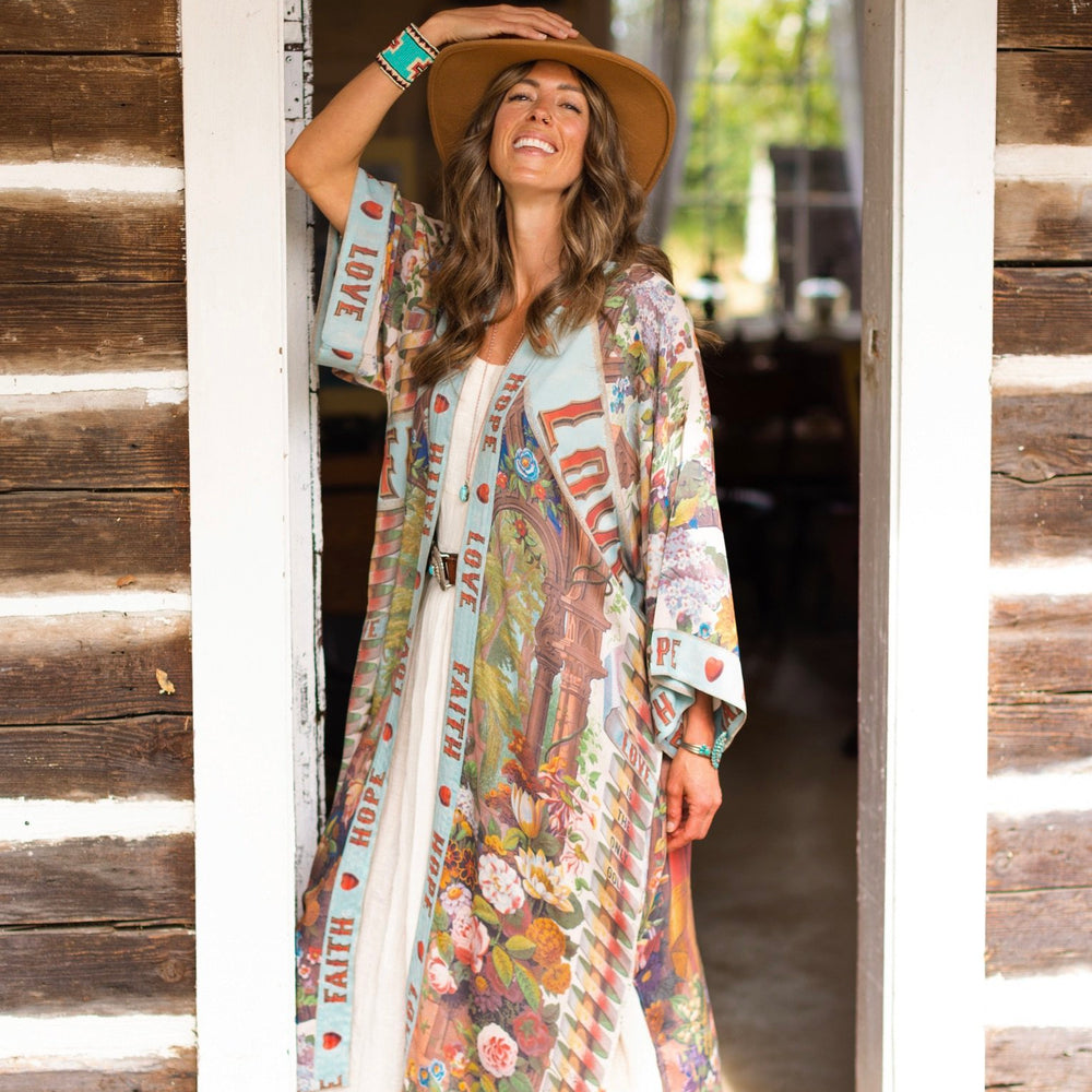 Model wearing romantic full-length kimono featuring joyful 1854 floral art, heart-in-hand symbol, and handwritten messages of love – Market of Stars