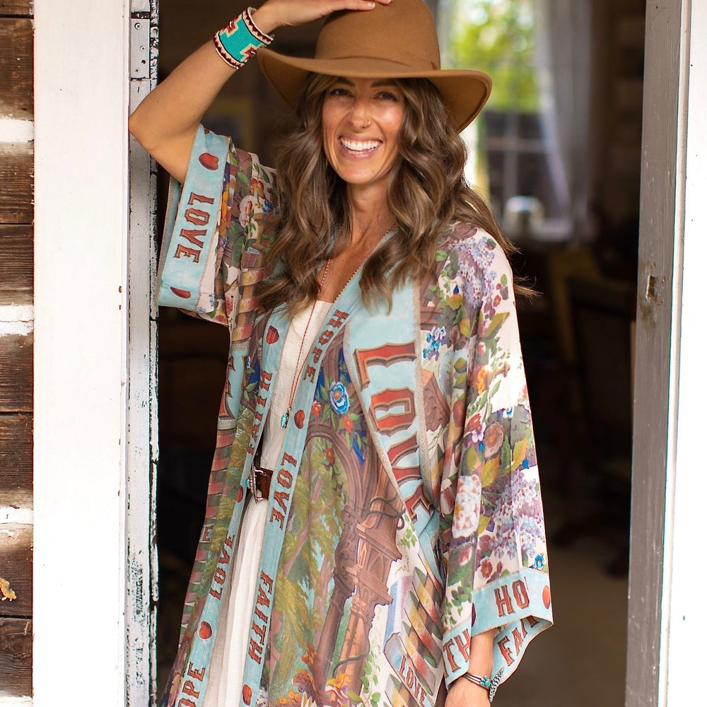 Model wearing romantic full-length kimono featuring joyful 1854 floral art, heart-in-hand symbol, and handwritten messages of love – Market of Stars