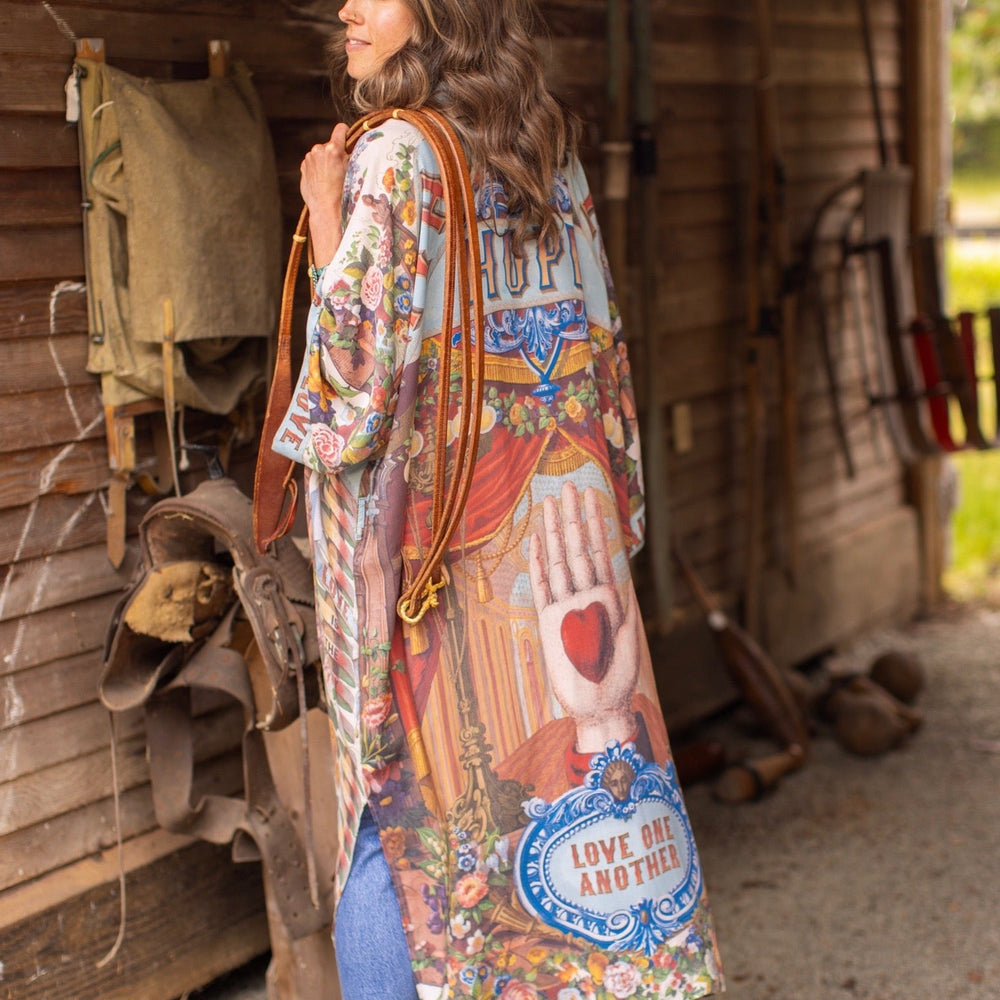 
                  
                    Model wearing romantic full-length kimono featuring joyful 1854 floral art, heart-in-hand symbol, and handwritten messages of love – Market of Stars
                  
                