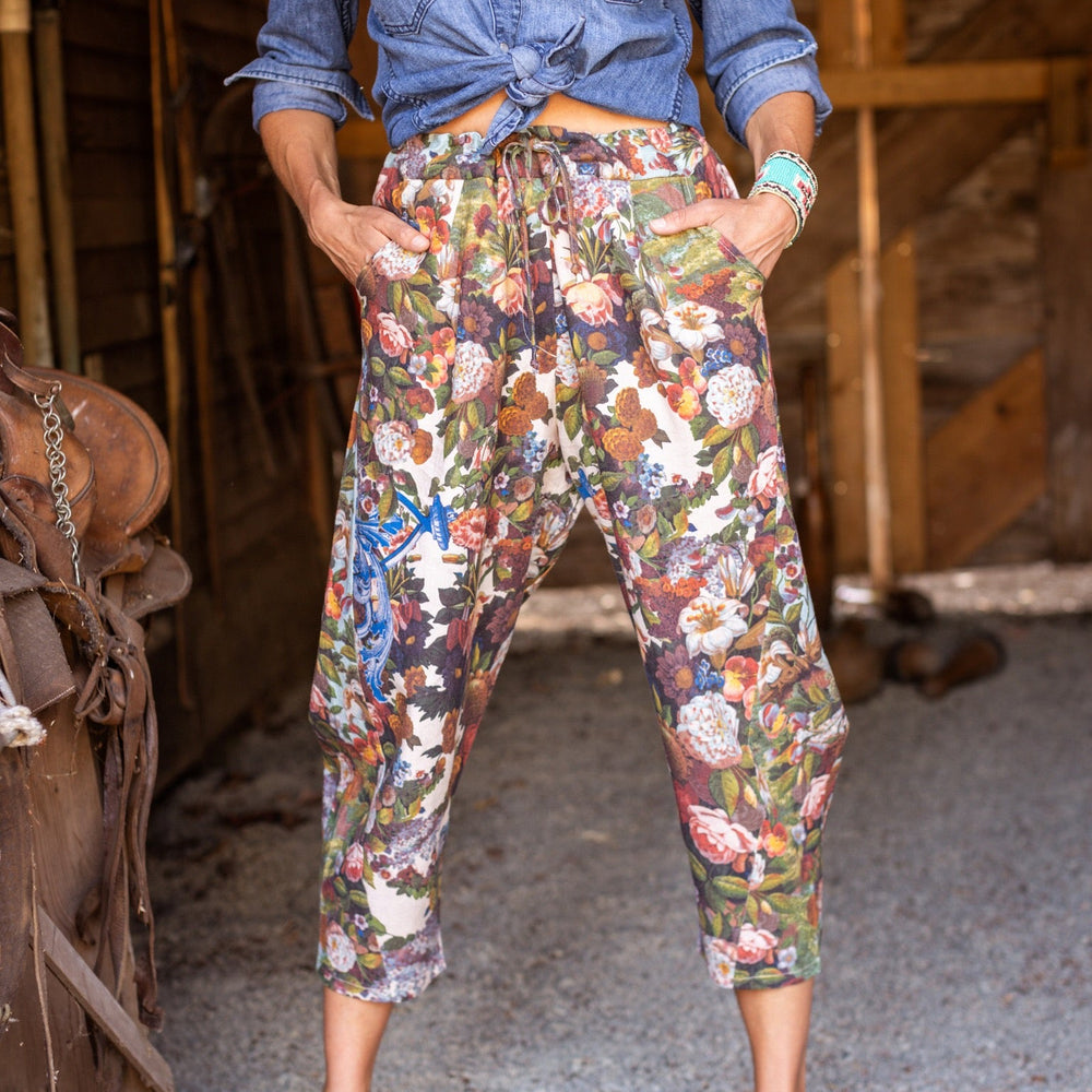 
                  
                    Model wearing linen blend artist pants with 1854 floral art, heart-in-hand symbol, and “Love one another” handwritten script – Market of Stars.
                  
                