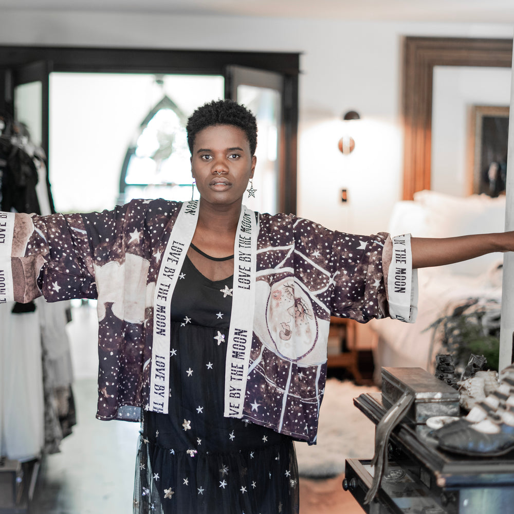 
                  
                    Model wearing Love By The Moon Kimono featuring sepia tones, vintage moon illustration, and retro typography inspired by early 1900s photo props – Market of Stars
                  
                