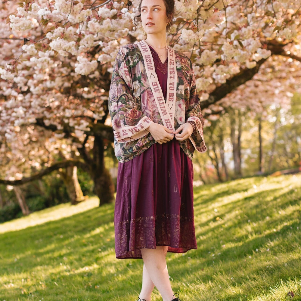 
                  
                    Model wearing cropped kimono featuring gold wishbone–vintage coin–evening star–dandelion–and spring floral collage with “Make a wish” banner – Market of Stars
                  
                
