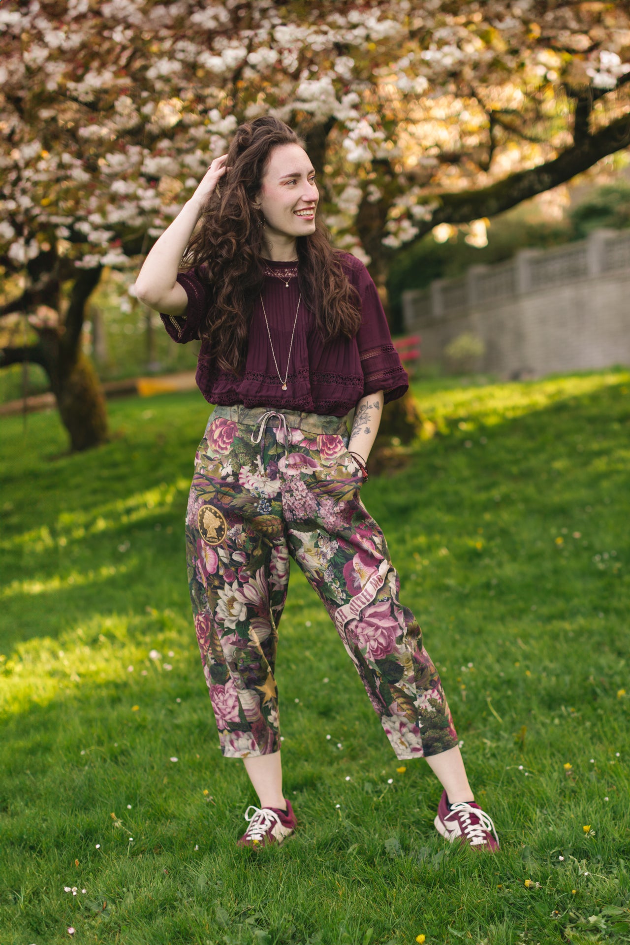 Model wearing linen blend artist pants featuring antique wishbone–Victorian coin–evening star–dandelion art and “Wish with Me” banner on floral background – Market of Stars