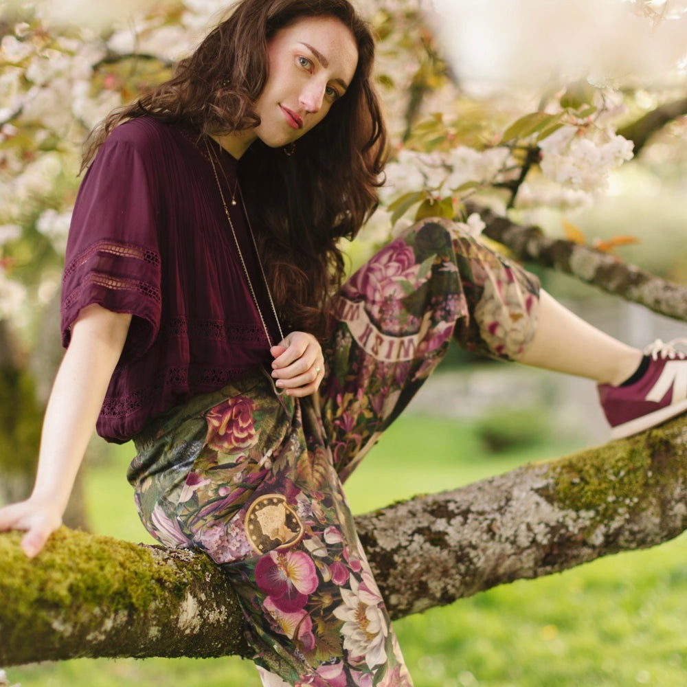 
                  
                    Model wearing linen blend artist pants featuring antique wishbone–Victorian coin–evening star–dandelion art and “Wish with Me” banner on floral background – Market of Stars
                  
                