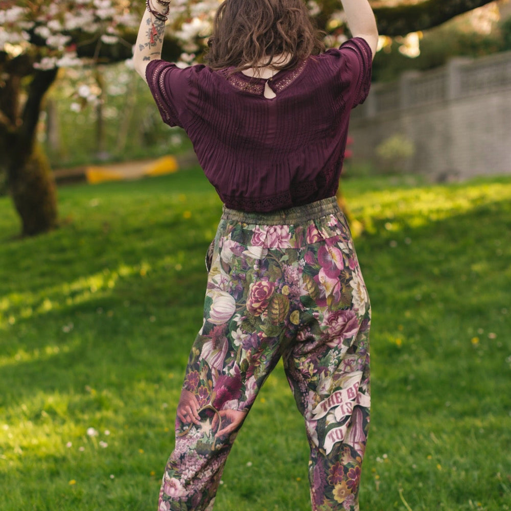 
                  
                    Model wearing linen blend artist pants featuring antique wishbone–Victorian coin–evening star–dandelion art and “Wish with Me” banner on floral background – Market of Stars
                  
                
