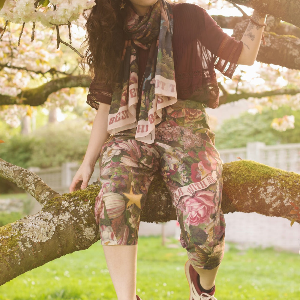 
                  
                    Model wearing linen blend artist pants featuring antique wishbone–Victorian coin–evening star–dandelion art and “Wish with Me” banner on floral background – Market of Stars
                  
                