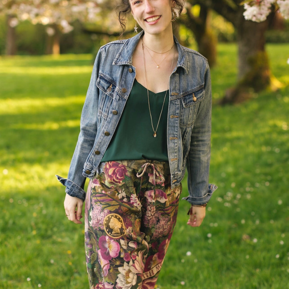 
                  
                    Model wearing linen blend artist pants featuring antique wishbone–Victorian coin–evening star–dandelion art and “Wish with Me” banner on floral background – Market of Stars
                  
                