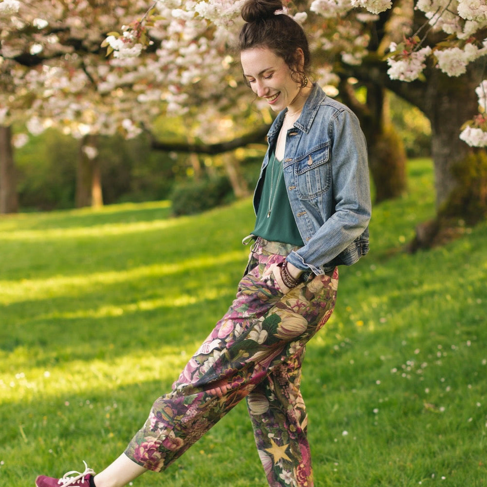 
                  
                    Model wearing linen blend artist pants featuring antique wishbone–Victorian coin–evening star–dandelion art and “Wish with Me” banner on floral background – Market of Stars
                  
                
