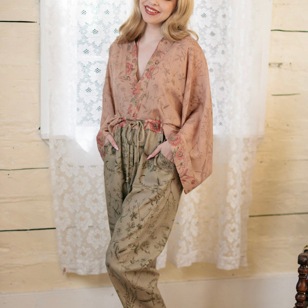 Model wearing artist pants in sage featuring reimagined vintage 1846 map of a woman’s heart with playful updated place names – Market of Stars