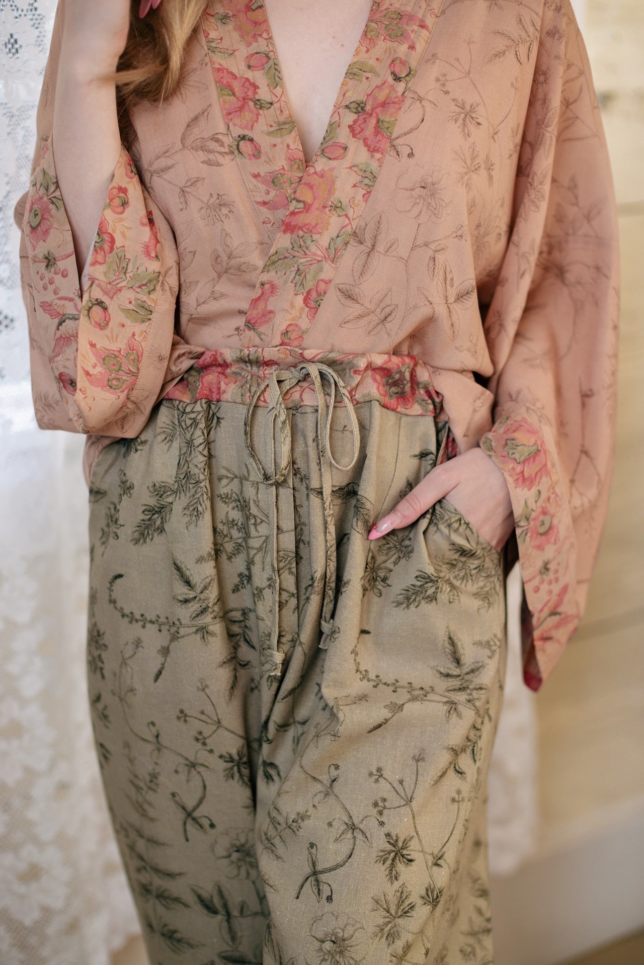 Model wearing artist pants in sage featuring reimagined vintage 1846 map of a woman’s heart with playful updated place names – Market of Stars