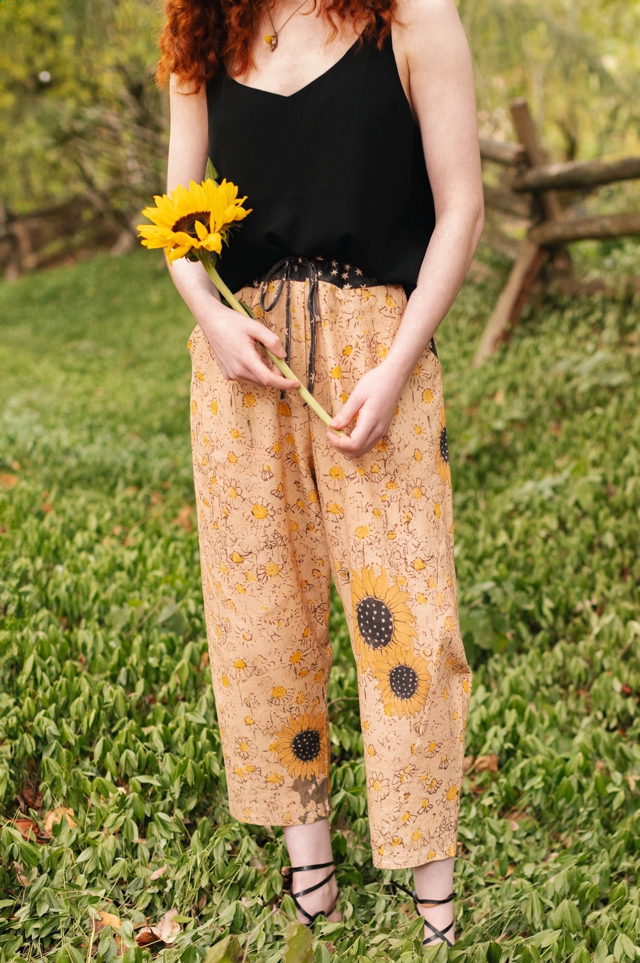 Model wearing the Milk & Honey Artist Pants featuring playful 1904 Brooklyn poster art and antique woodcut star and floral details in vintage-inspired tones – Market of Stars.