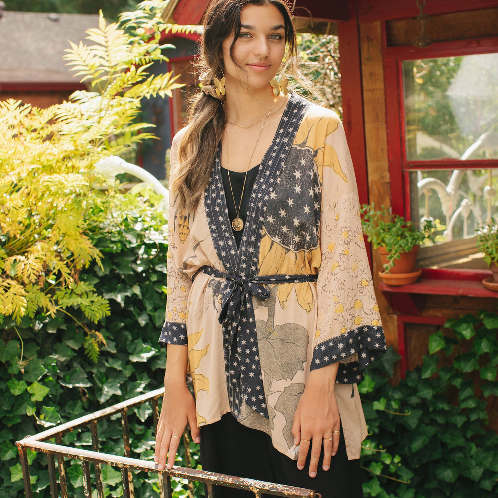 Model wearing our matinee length kimono featuring vintage-inspired Milk & Honey print with 1904 typography and floral woodcuts – Market of Stars