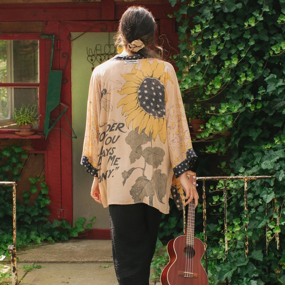 Model wearing our matinee length kimono featuring vintage-inspired Milk & Honey print with 1904 typography and floral woodcuts – Market of Stars