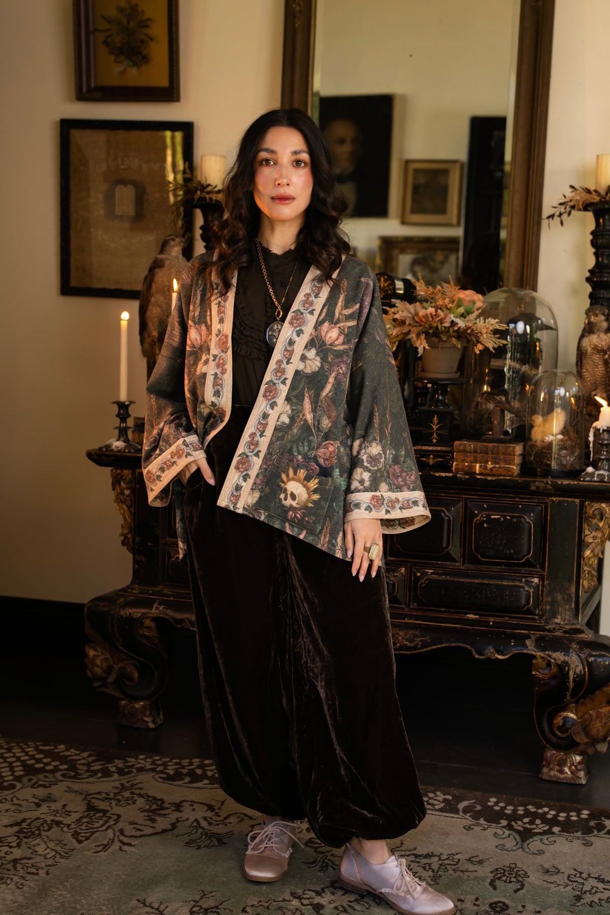 Model wearing a cozy fleece lined cottage cardigan ft. artwork created by Jessica Roux including two starlings beneath a full moon with flowers, butterflies, moths and botanical artwork - Market of Stars