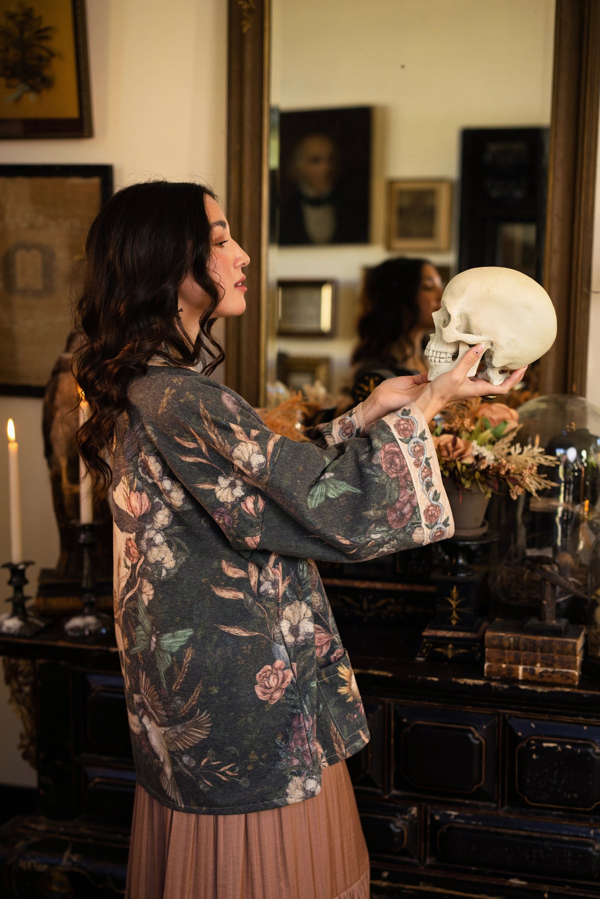 Model wearing a cozy fleece lined cottage cardigan ft. artwork created by Jessica Roux including two starlings beneath a full moon with flowers, butterflies, moths and botanical artwork - Market of Stars