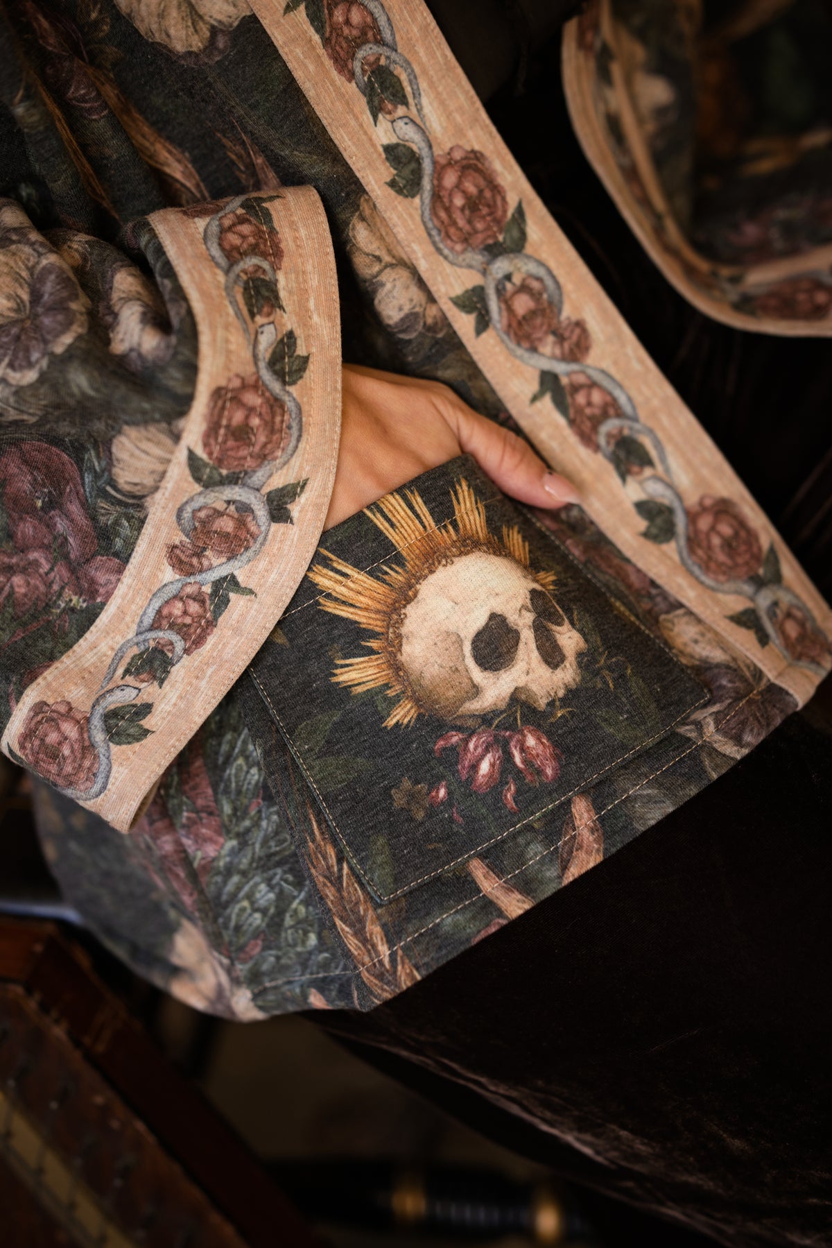 Model wearing a cozy fleece lined cottage cardigan ft. artwork created by Jessica Roux including two starlings beneath a full moon with flowers, butterflies, moths and botanical artwork - Market of Stars