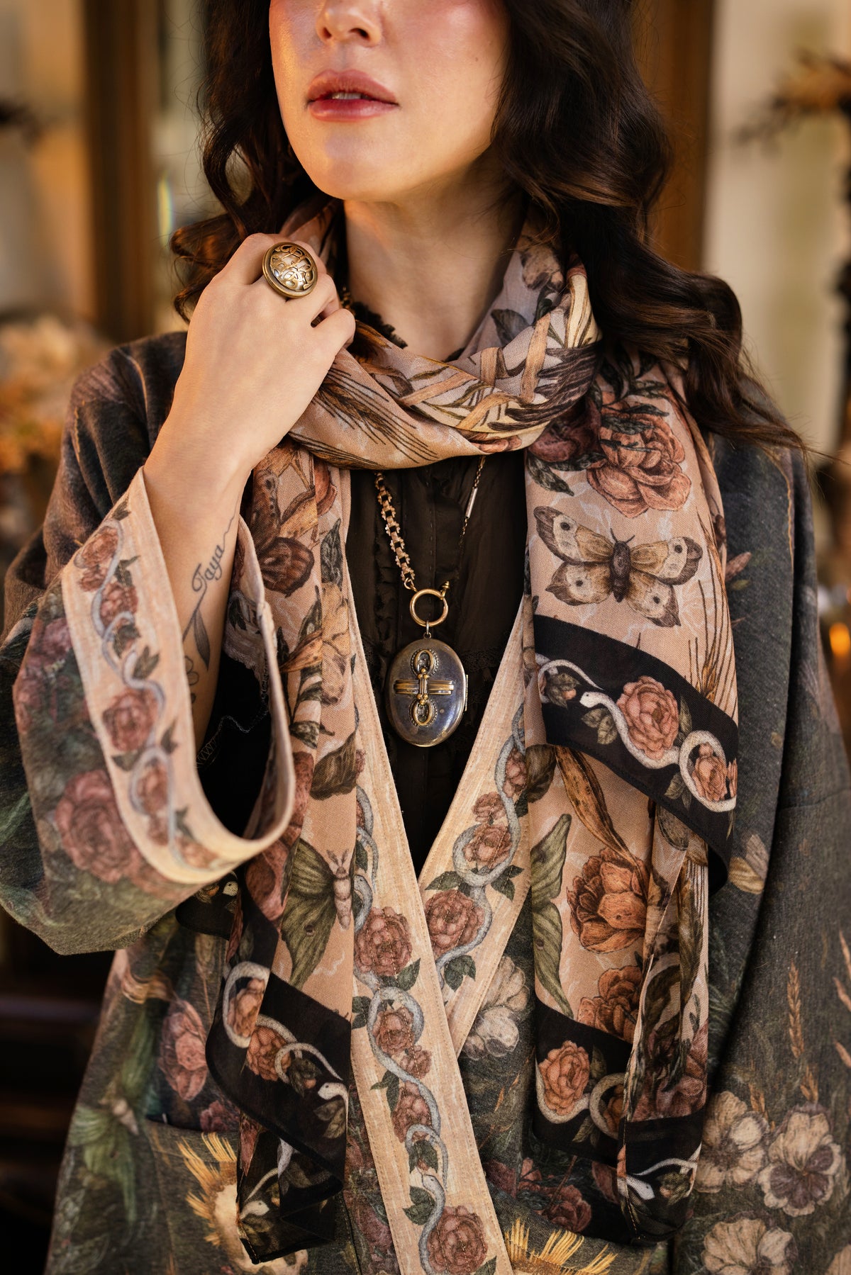 Model wearing a cozy fleece lined cottage cardigan ft. artwork created by Jessica Roux including two starlings beneath a full moon with flowers, butterflies, moths and botanical artwork - Market of Stars